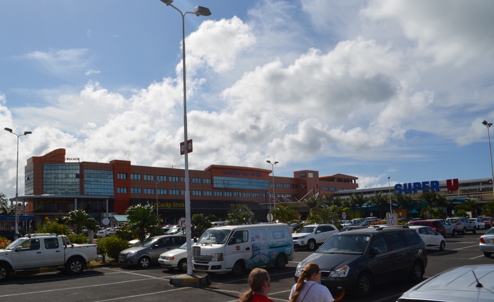Großer Parkplatz vor dem Einkaufszentrum Grand Baie La Croisette mit Pick-up, Kleinbus und Pkw